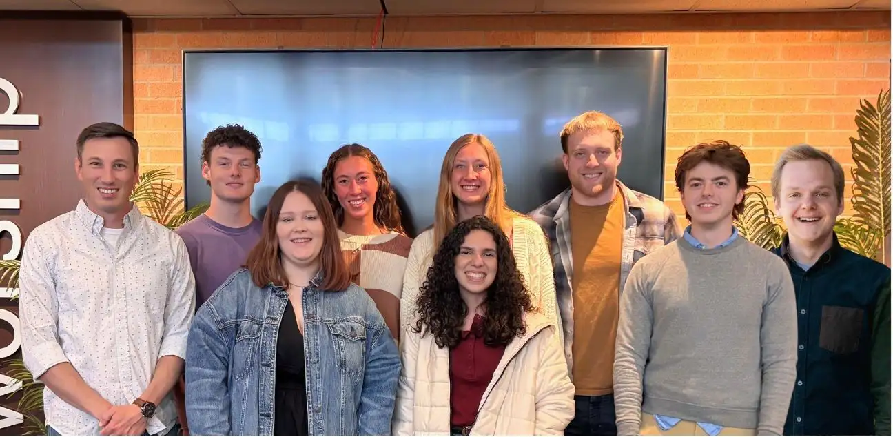Group of young adults smiling together in a church setting, representing the GraceWay Bible Church missions team preparing for outreach activities.